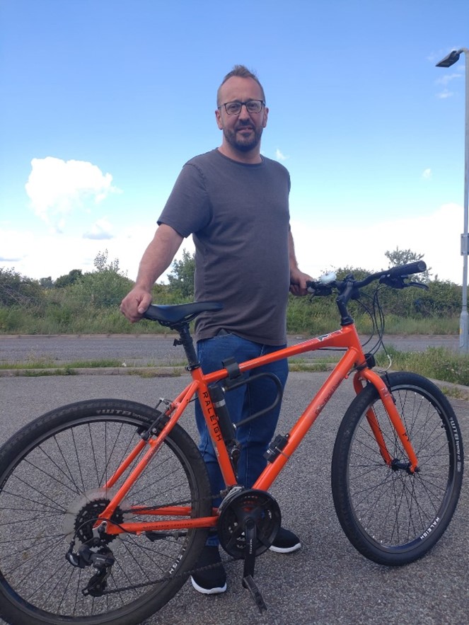 Kevin standing with his bike